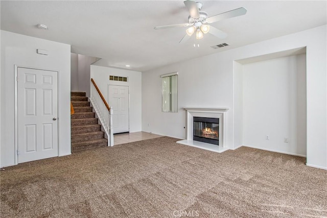 unfurnished living room featuring ceiling fan and light carpet