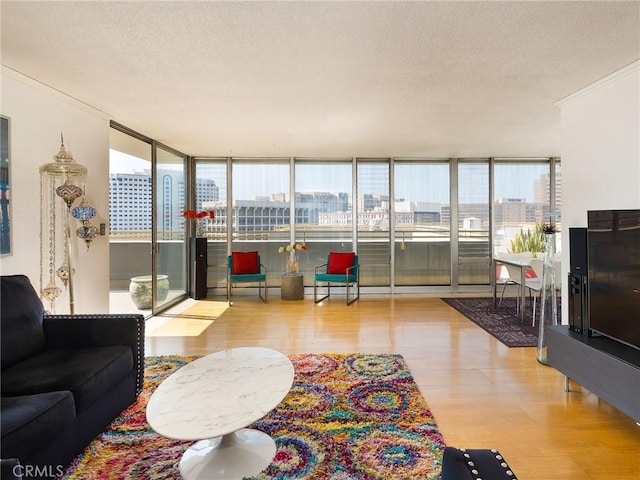 living room with a wealth of natural light, light hardwood / wood-style flooring, and a textured ceiling