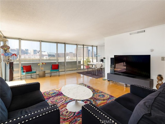 living room with floor to ceiling windows, wood-type flooring, and a textured ceiling