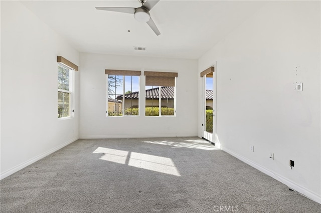 carpeted empty room with a wealth of natural light and ceiling fan