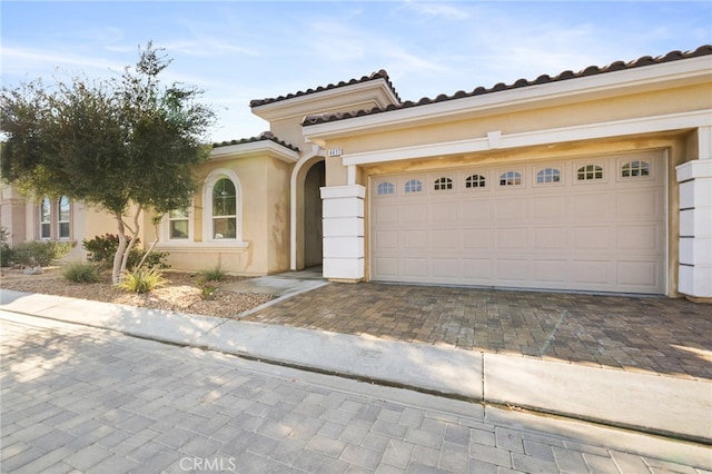 mediterranean / spanish home with a garage