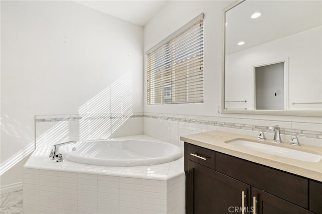 bathroom with tiled bath and vanity