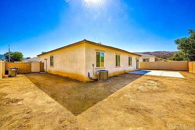 rear view of house with cooling unit and a patio area