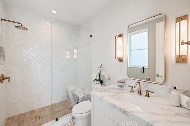 bathroom featuring vanity, toilet, and a shower with shower door