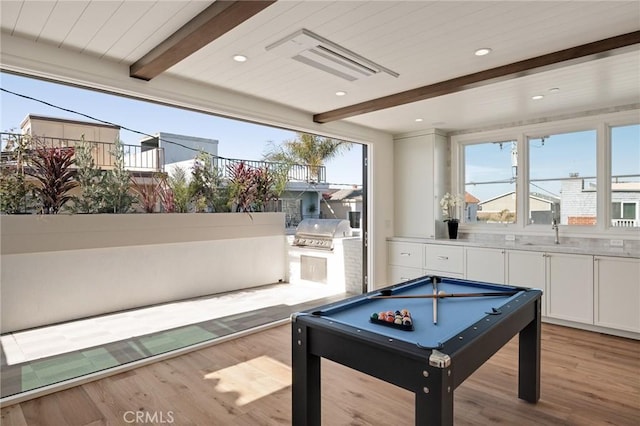 game room featuring sink, pool table, light hardwood / wood-style flooring, and beamed ceiling