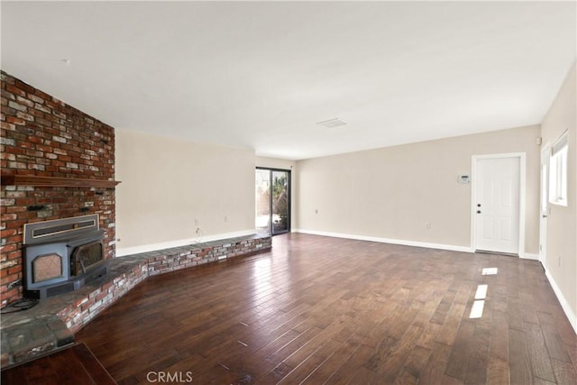 unfurnished living room with dark hardwood / wood-style flooring and a wood stove