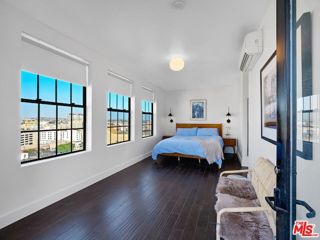 bedroom with a wall mounted air conditioner and hardwood / wood-style flooring