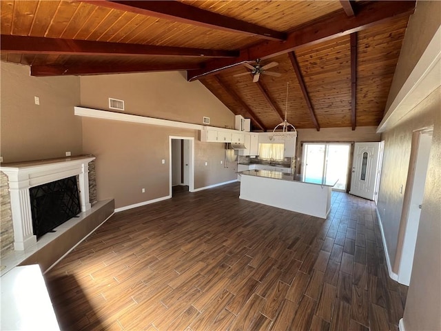 unfurnished living room with ceiling fan, beam ceiling, high vaulted ceiling, wooden ceiling, and a fireplace