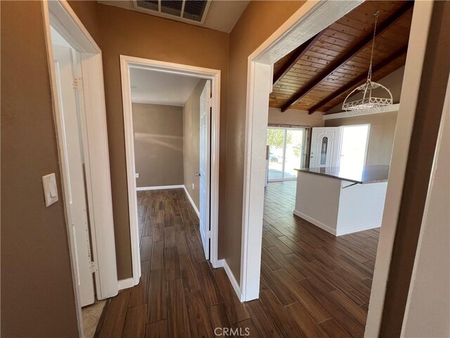 hallway featuring lofted ceiling with beams, dark wood-type flooring, wooden ceiling, and an inviting chandelier