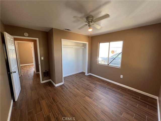 unfurnished bedroom featuring ceiling fan, dark hardwood / wood-style floors, and a closet