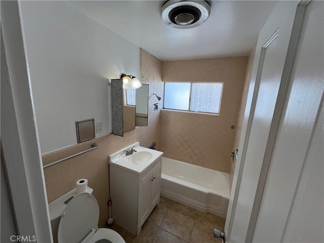 bathroom with tile patterned floors, vanity, tile walls, and toilet