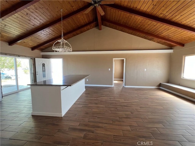 kitchen featuring wooden ceiling, beamed ceiling, high vaulted ceiling, dark stone countertops, and pendant lighting