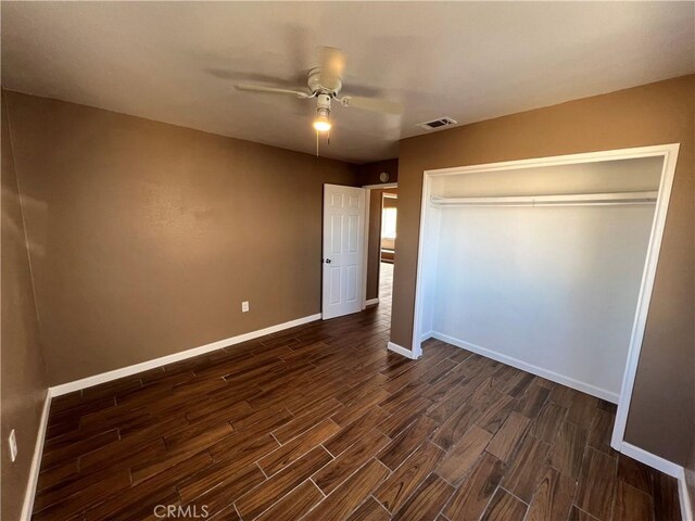 unfurnished bedroom with ceiling fan and a closet