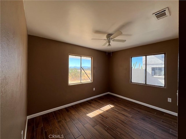 spare room featuring ceiling fan and dark wood-type flooring