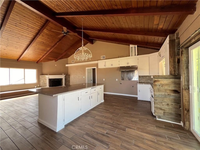 kitchen featuring kitchen peninsula, ceiling fan, beam ceiling, white cabinetry, and wood ceiling