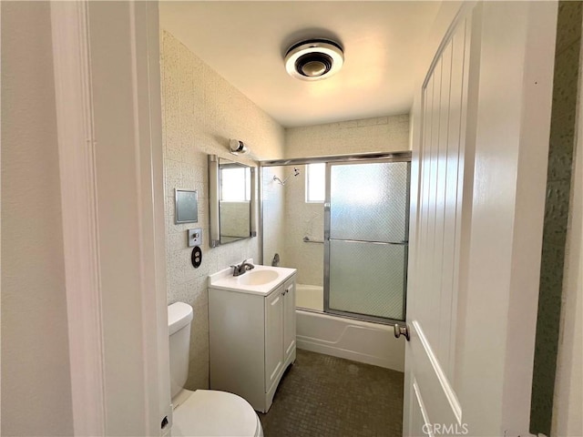 full bathroom with vanity, toilet, and bath / shower combo with glass door