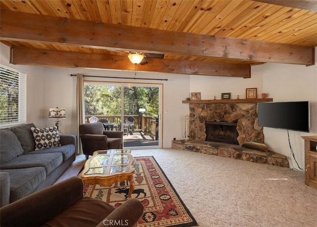 carpeted living room featuring wooden ceiling, a stone fireplace, ceiling fan, and plenty of natural light