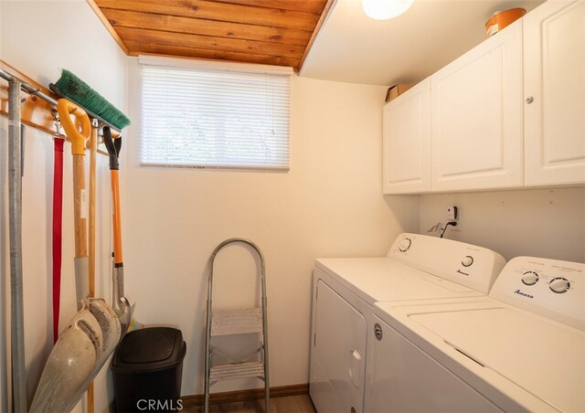 laundry room featuring wooden ceiling, dark wood-type flooring, washing machine and clothes dryer, and cabinets