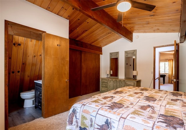 carpeted bedroom featuring wood ceiling, lofted ceiling with beams, ensuite bath, and ceiling fan