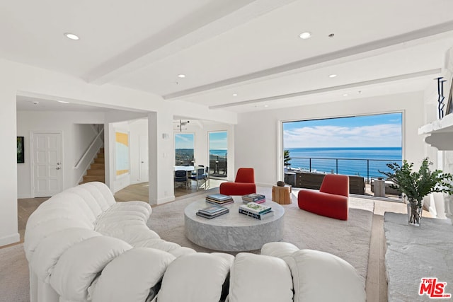 living room featuring a water view and beamed ceiling