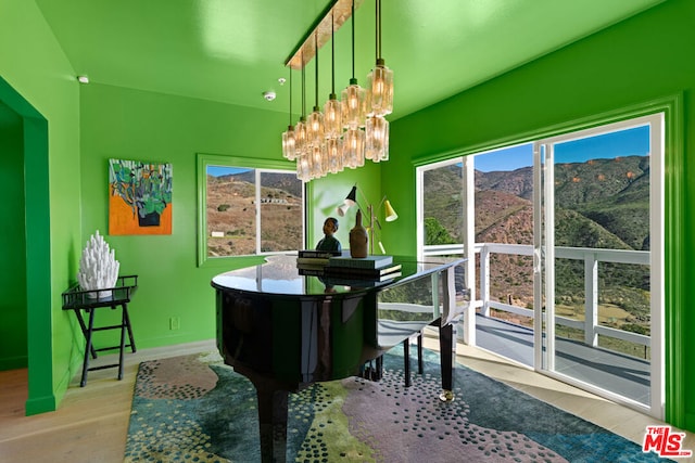 misc room with light wood-type flooring, an inviting chandelier, and a mountain view