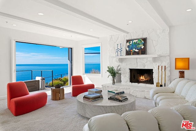 carpeted living room featuring beam ceiling, a water view, and a stone fireplace