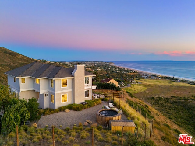 exterior space with a water view and an outdoor fire pit