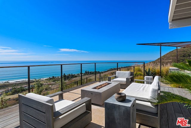 view of patio / terrace with a water view and an outdoor living space with a fire pit