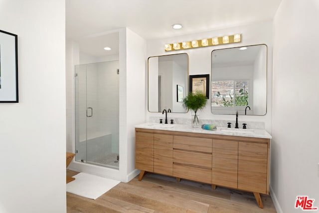 bathroom featuring hardwood / wood-style floors, an enclosed shower, and vanity