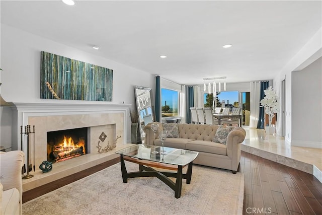 living room featuring baseboards, a fireplace, wood finished floors, and recessed lighting