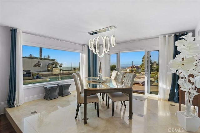 dining space featuring tile patterned flooring and a notable chandelier