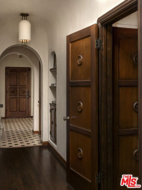 hall featuring dark wood-type flooring and built in features