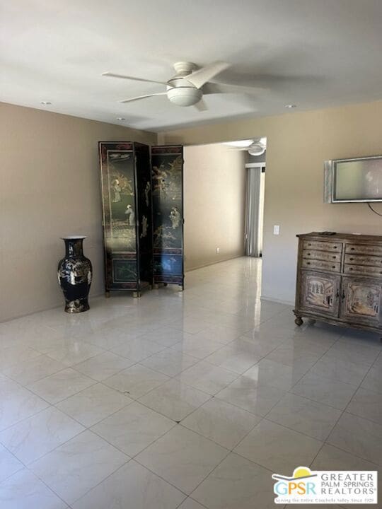 tiled empty room featuring ceiling fan