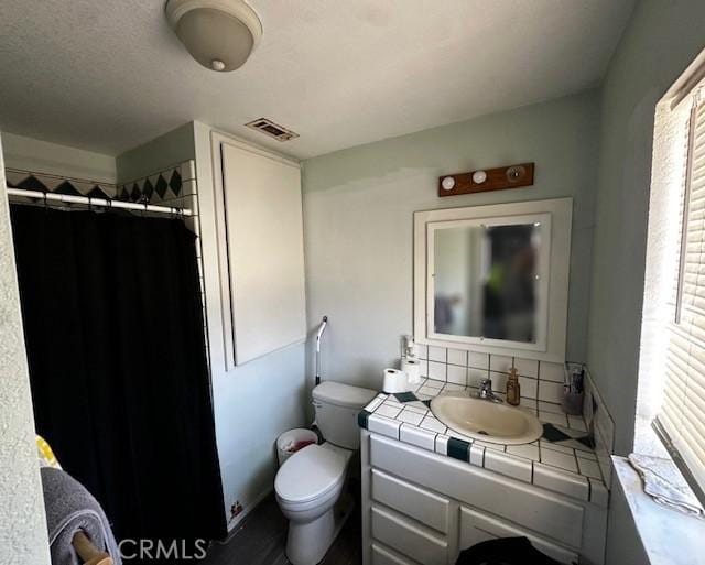 bathroom with tasteful backsplash, vanity, toilet, a shower with shower curtain, and visible vents