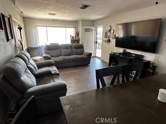 living area featuring visible vents and wood finished floors