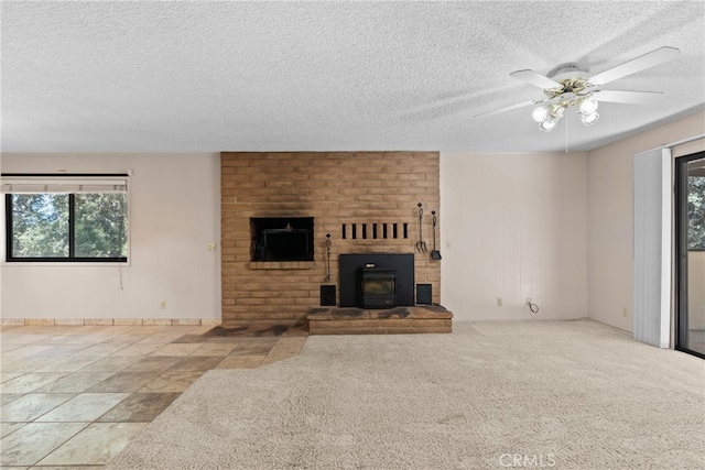 unfurnished living room featuring a textured ceiling, a healthy amount of sunlight, a fireplace, and ceiling fan