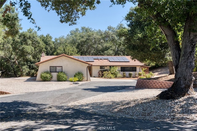 ranch-style house with solar panels