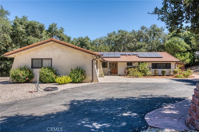 ranch-style home with solar panels