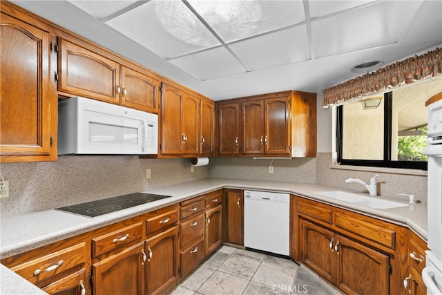 kitchen with white appliances, light tile patterned flooring, and sink