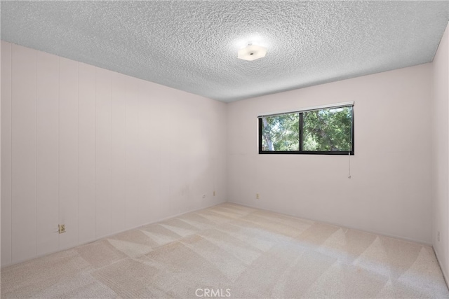 carpeted empty room featuring a textured ceiling