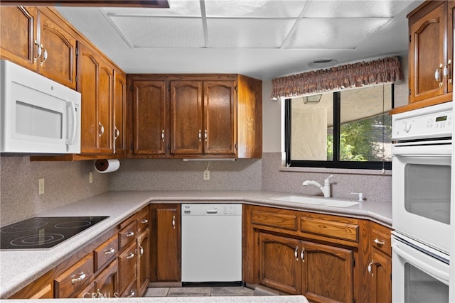 kitchen featuring backsplash, sink, and white appliances