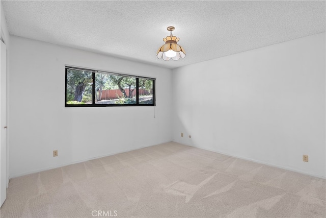 carpeted empty room with a textured ceiling