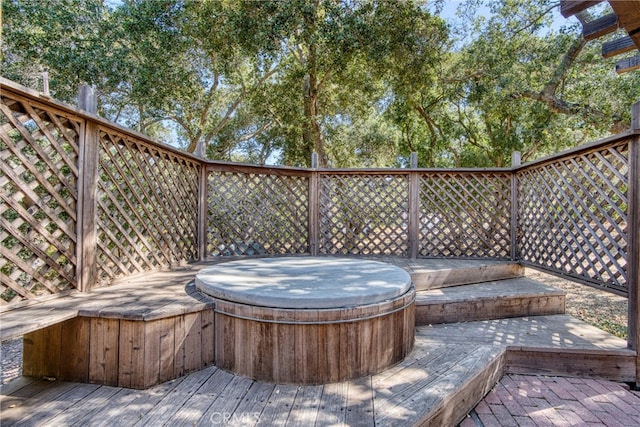 wooden deck featuring a covered hot tub