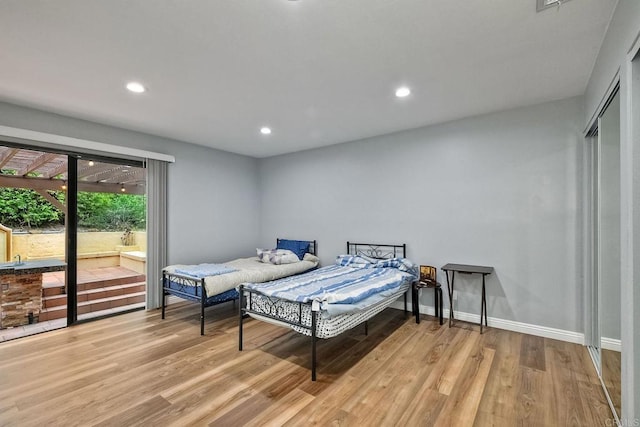 bedroom featuring access to outside and light hardwood / wood-style floors