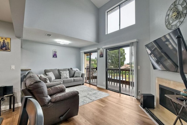 living room with a high ceiling and light hardwood / wood-style flooring