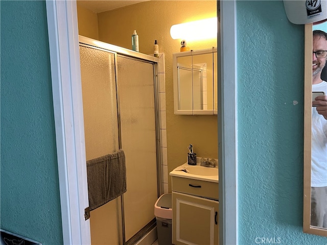 bathroom with an enclosed shower, vanity, and toilet