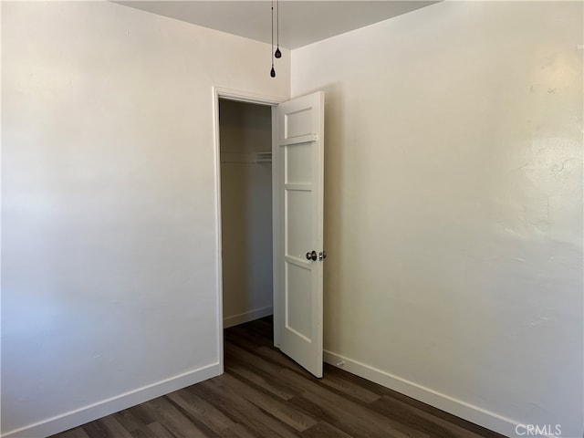 unfurnished bedroom featuring dark wood-type flooring and a closet