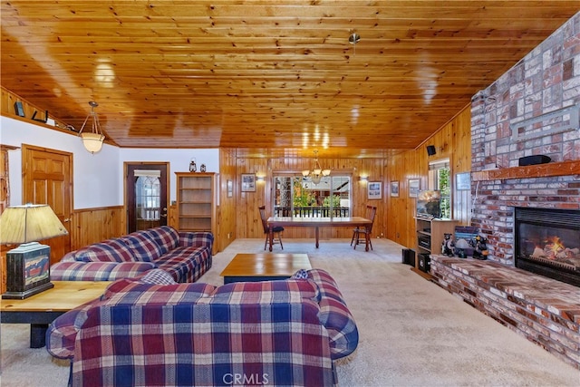 carpeted living room featuring vaulted ceiling, a fireplace, wood walls, a chandelier, and wood ceiling