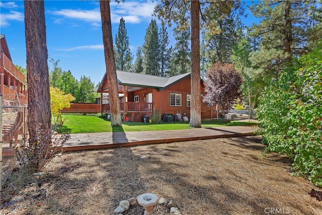 back of property featuring a yard, fence, and a deck