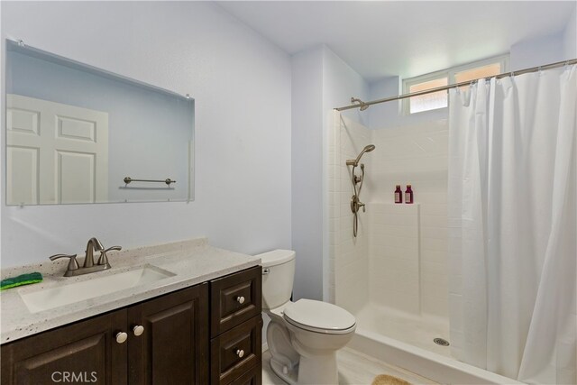 bathroom with vanity, curtained shower, and toilet